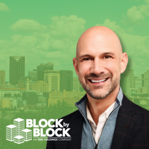 Aaron Perri smiles in front of a cityscape.